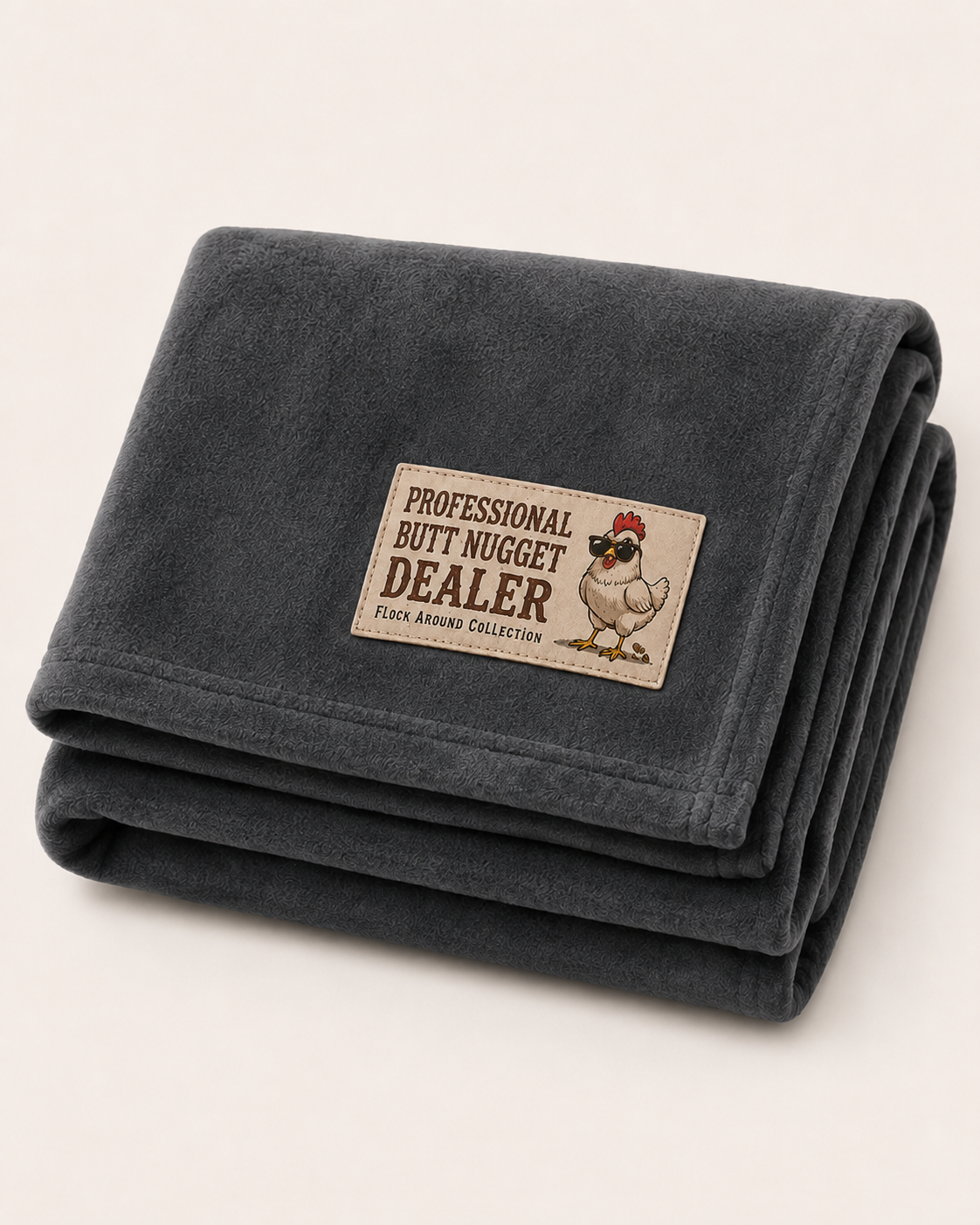 Flock Around fleece stadium blanket in charcoal, folded, with Professional Butt Nugget Dealer patch